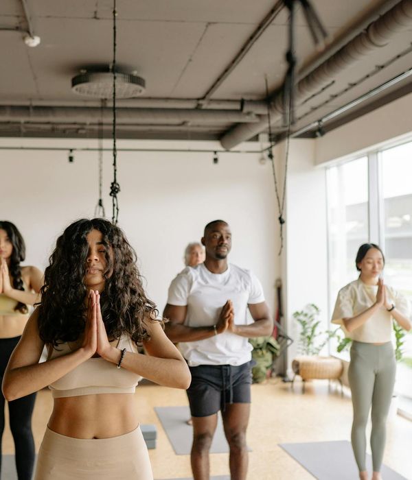 Person practicing gentle yoga movements in a dark premium studio